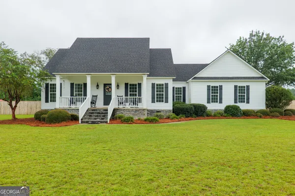 a view of house with yard and outdoor seating