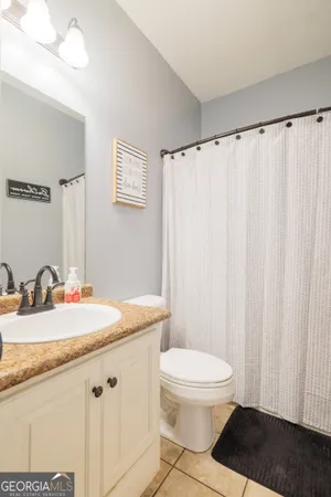 a bathroom with a granite countertop sink toilet and a mirror