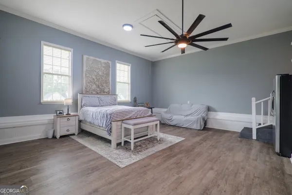 a bedroom with a bed wooden floor and window