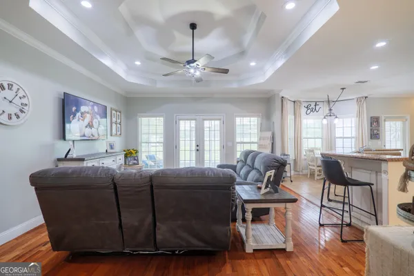 a living room with furniture a dining table and a large window