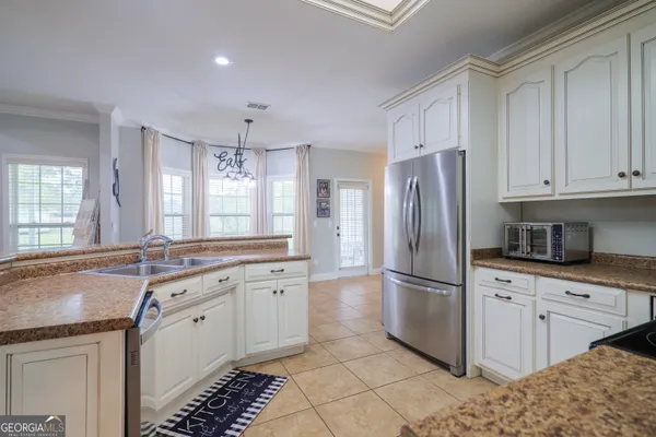 a kitchen with granite countertop a refrigerator sink stove and cabinets