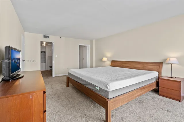 a bedroom with a bed and a flat tv screen on wall