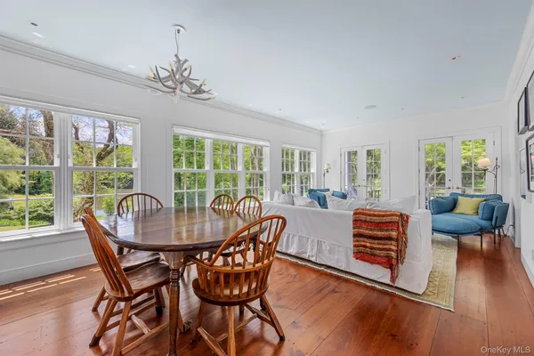 a dining room with furniture a chandelier and wooden floor