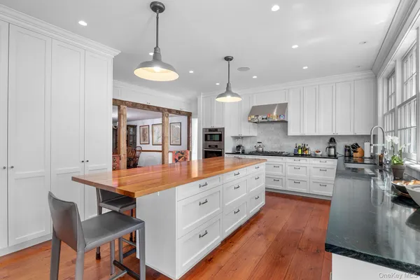 a large kitchen with lots of counter space and wooden floor