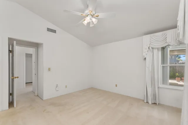 a view of a room with a ceiling fan and a window