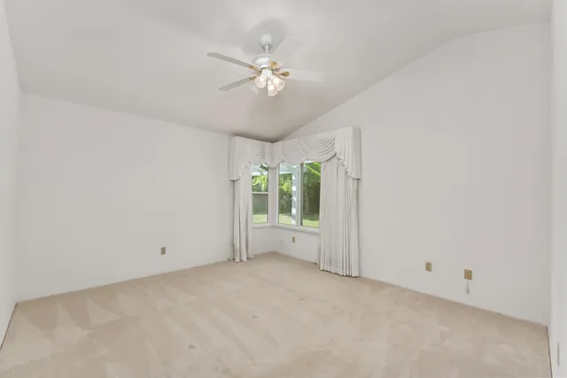 an empty room with chandelier fan