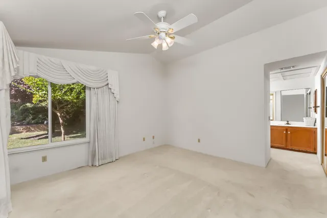 an empty room with a window and a ceiling fan