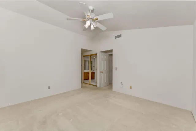 a view of an empty room with a ceiling fan