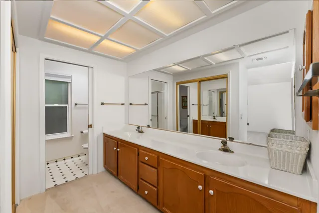 a spacious bathroom with a double vanity sink a mirror and a bathtub
