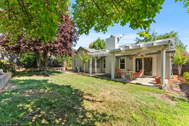 a view of a house with backyard garden and sitting area
