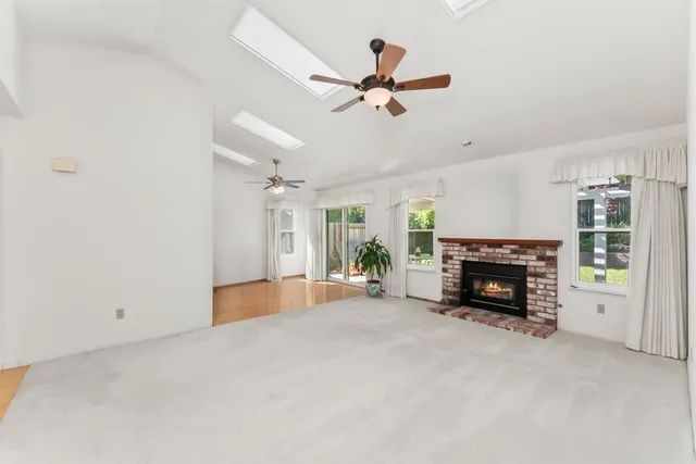 a view of an empty room with fireplace and a window