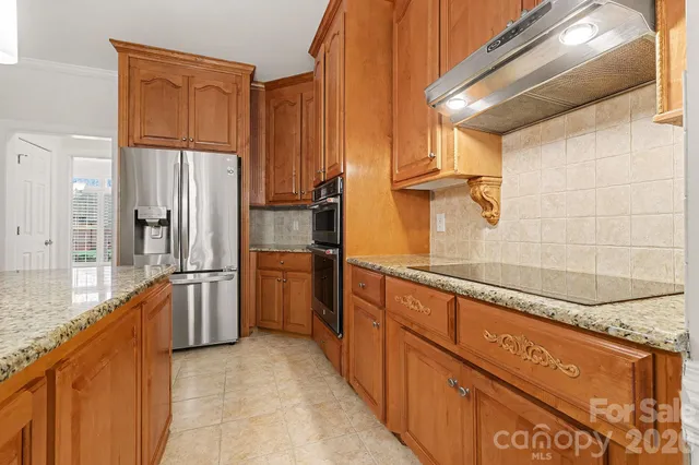 a kitchen with stainless steel appliances granite countertop a refrigerator and a sink