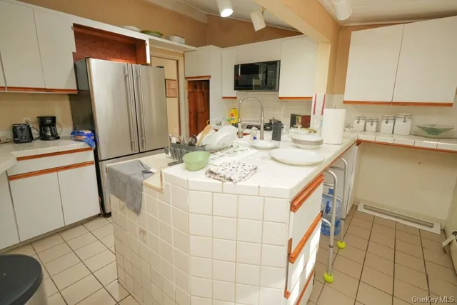 a kitchen with stainless steel appliances granite countertop a sink a stove a microwave a refrigerator and island