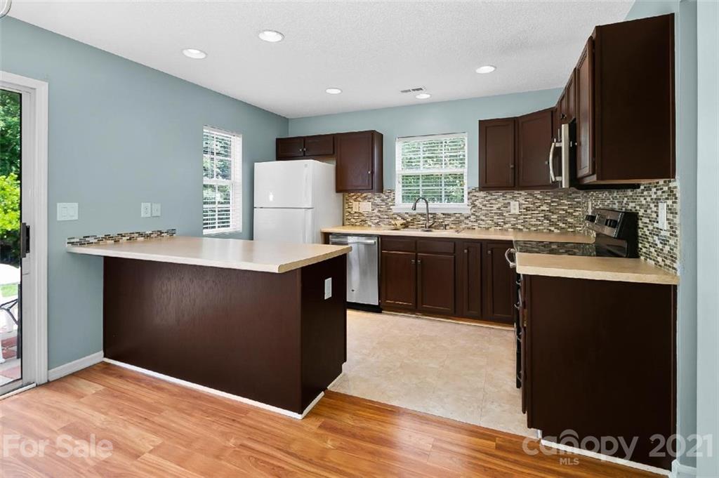 10930 Kinston Ridge Place, Unit 1237 Charlotte, NC 28273 - Photo 20 of 32 a kitchen with stainless steel appliances granite countertop a stove a sink and a microwave