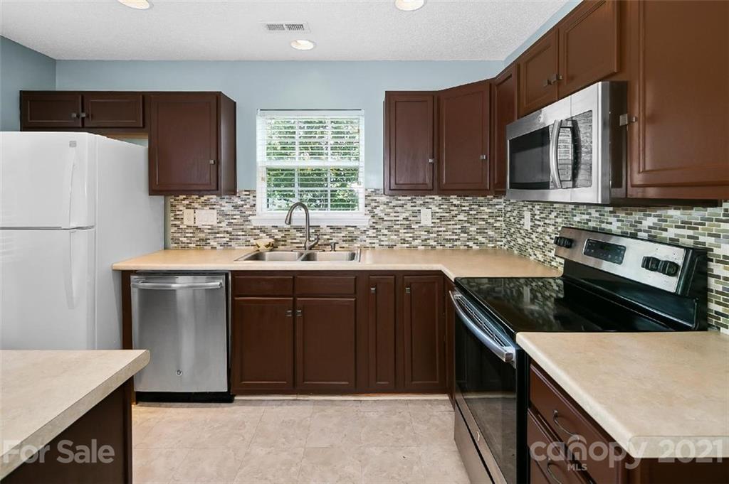 10930 Kinston Ridge Place, Unit 1237 Charlotte, NC 28273 - Photo 23 of 32 a kitchen with stainless steel appliances granite countertop a stove a sink and a microwave
