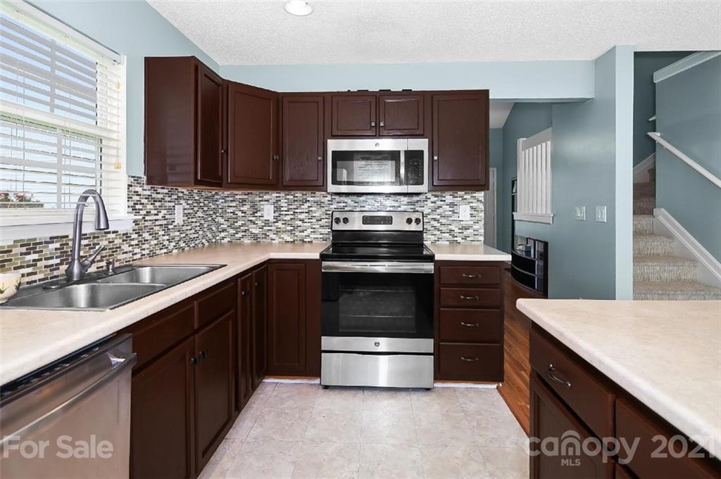 10930 Kinston Ridge Place, Unit 1237 Charlotte, NC 28273 - Photo 24 of 32 a kitchen with a sink stove and microwave