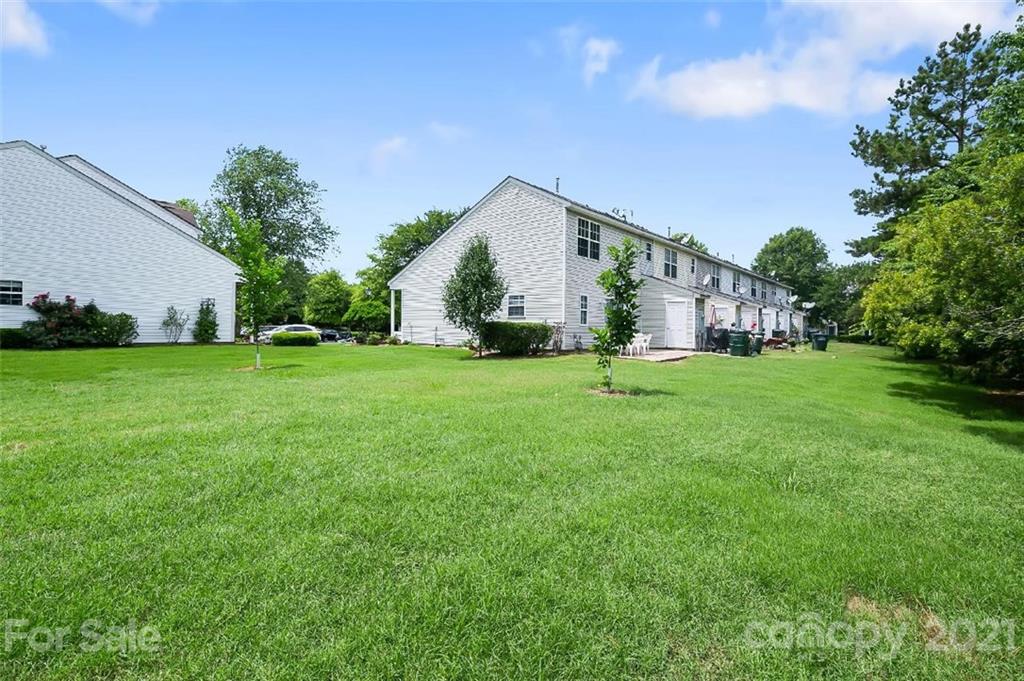 10930 Kinston Ridge Place, Unit 1237 Charlotte, NC 28273 - Photo 6 of 32 a backyard of a house with plants and large trees