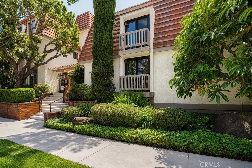 10470 Riverside Drive, Unit 102 Toluca Lake, CA 91602 - Photo 1 of 35 a front view of a house with a yard and potted plants
