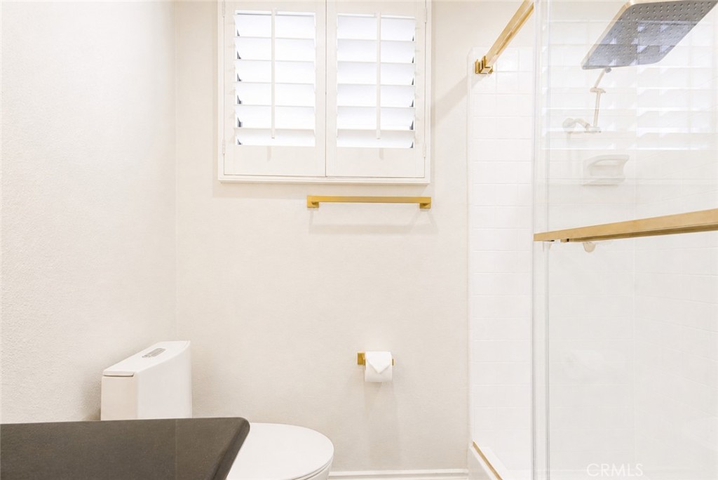 10470 Riverside Drive, Unit 102 Toluca Lake, CA 91602 - Photo 22 of 35 a bathroom with a window a toilet and a sink