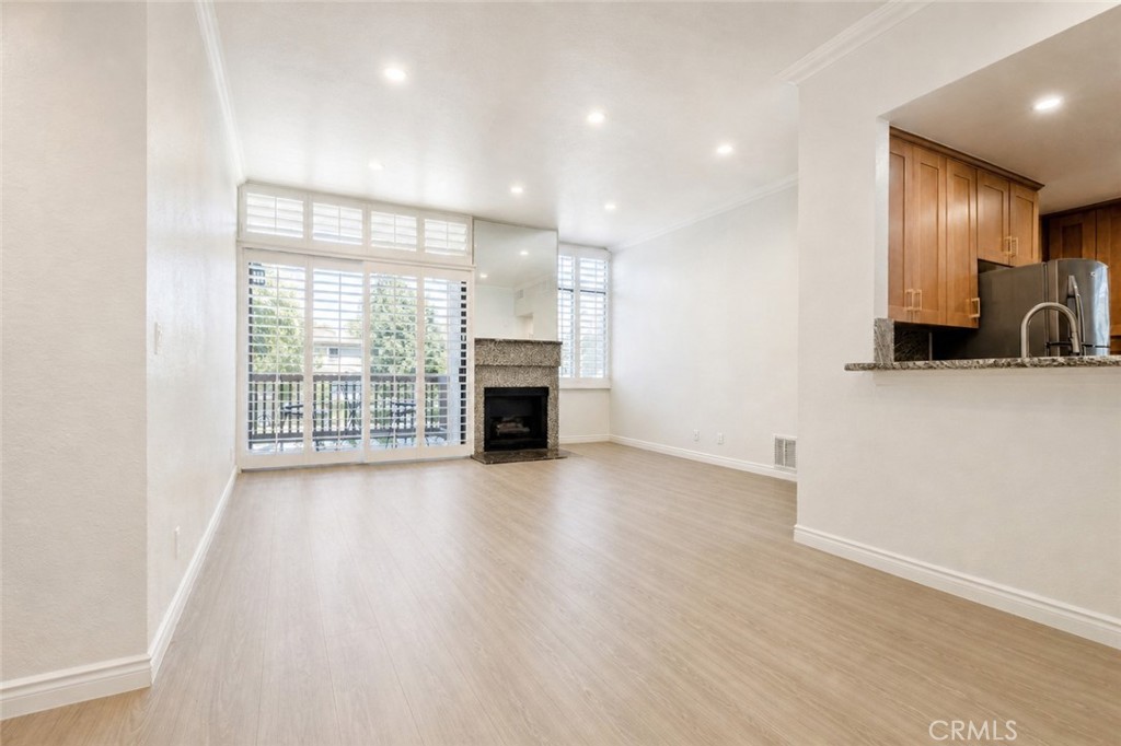 10470 Riverside Drive, Unit 102 Toluca Lake, CA 91602 - Photo 5 of 35 an empty room with wooden floor and a fireplace