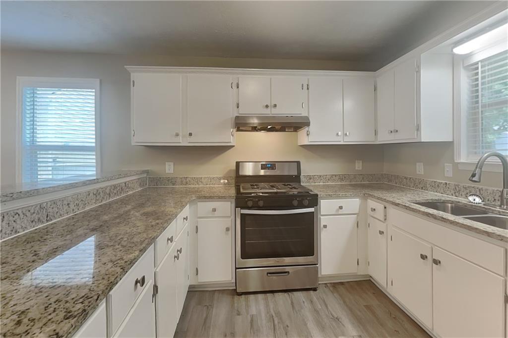 335 Olde Bridge Way Johns Creek, GA 30022 - Photo 4 of 19 a kitchen with granite countertop white cabinets and stainless steel appliances