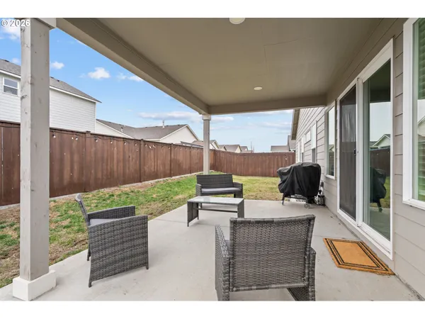 a backyard of a house with couches and wooden fence