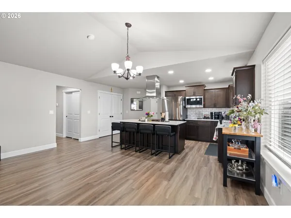 a living room with kitchen island furniture and a chandelier