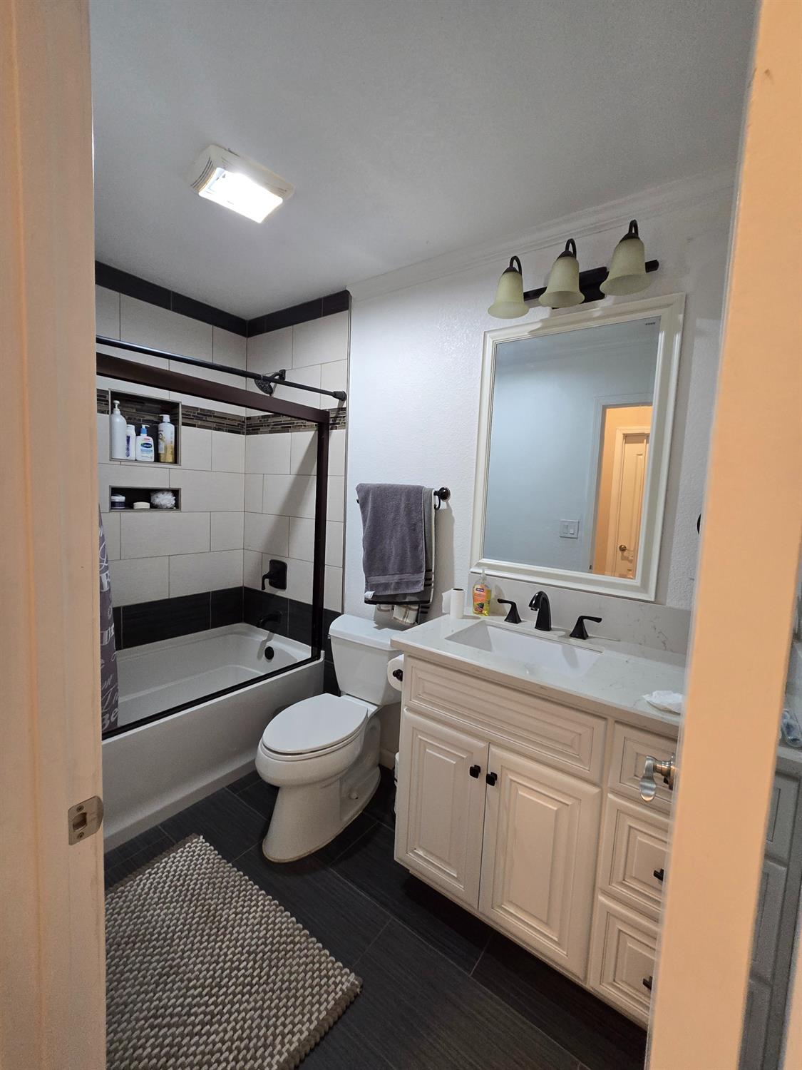 5995 West Brooks Road Merced, CA 95341 - Photo 11 of 23 a bathroom with a toilet a sink a mirror a vanity and shower