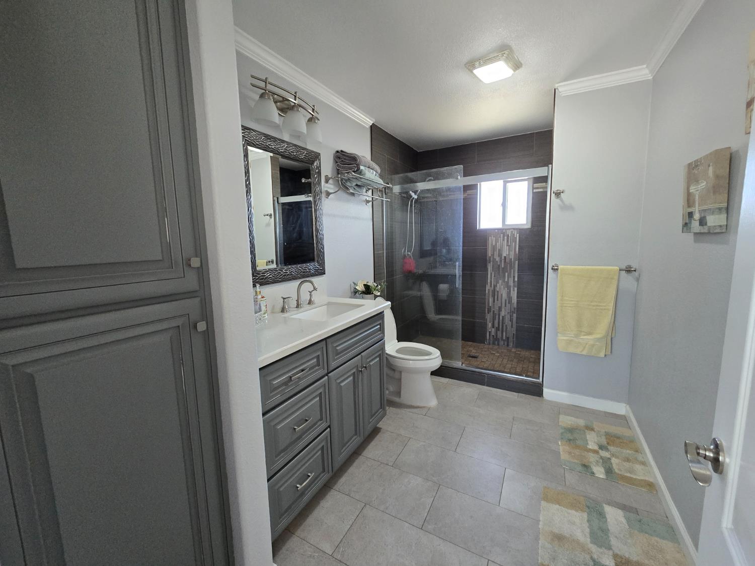 5995 West Brooks Road Merced, CA 95341 - Photo 16 of 23 a bathroom with a double vanity sink toilet mirror and shower