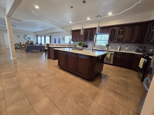 a kitchen with kitchen island granite countertop wooden cabinets and stainless steel appliances