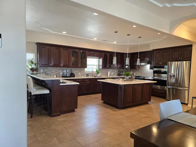 a kitchen with stainless steel appliances granite countertop a sink counter space cabinets and a large window