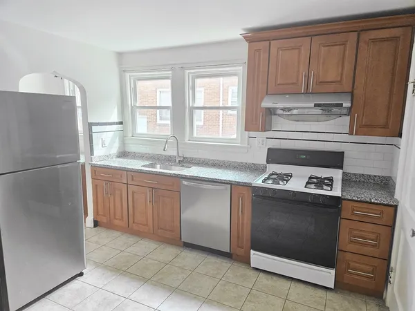 a kitchen with kitchen island granite countertop a refrigerator stove top oven and sink