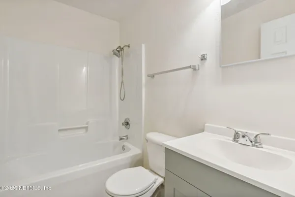 a bathroom with a sink toilet vanity and bathtub