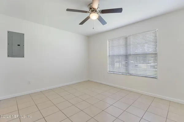 an empty room with closet and a chandelier fan