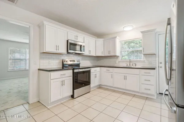 a kitchen with stainless steel appliances a refrigerator sink and microwave