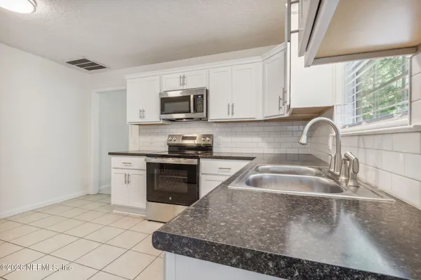 a kitchen with a refrigerator and cabinets