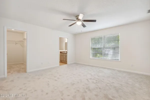 an empty room with a window and a fan