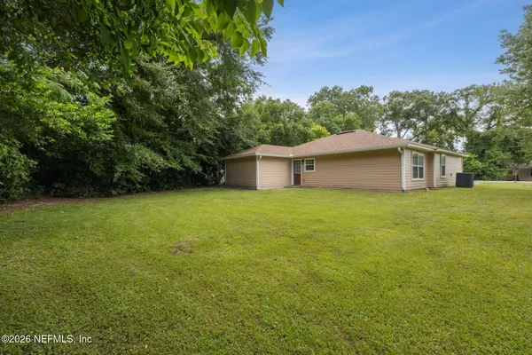 a view of backyard of house with green space