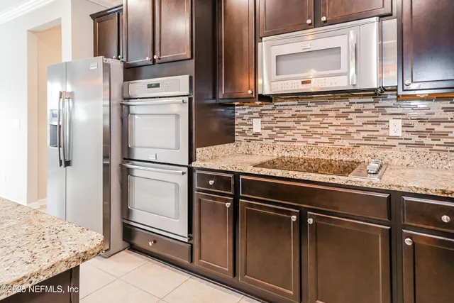 a kitchen with granite countertop stainless steel appliances and refrigerator