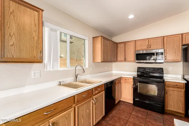 a kitchen with stainless steel appliances and granite countertop wooden cabinets