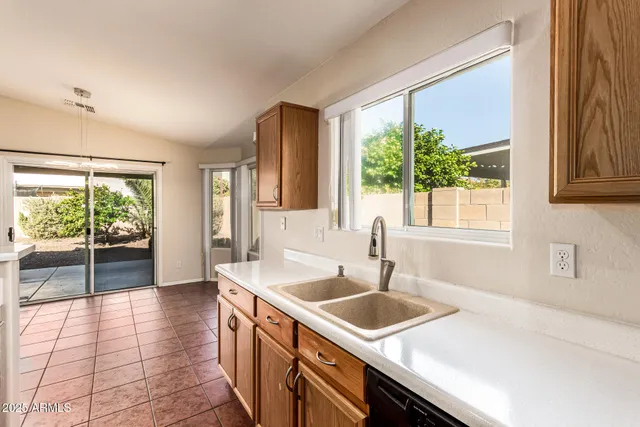 an empty room with wooden floor chandelier fan and windows