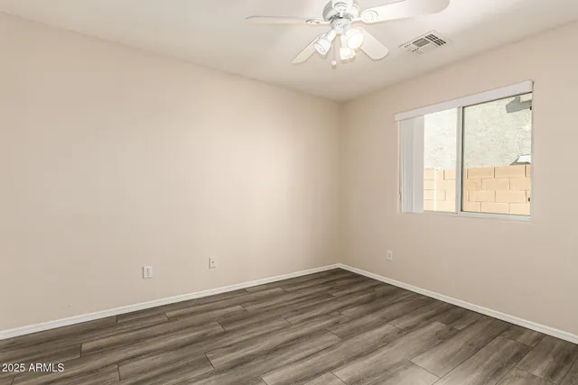 an empty room with wooden floor and closet area