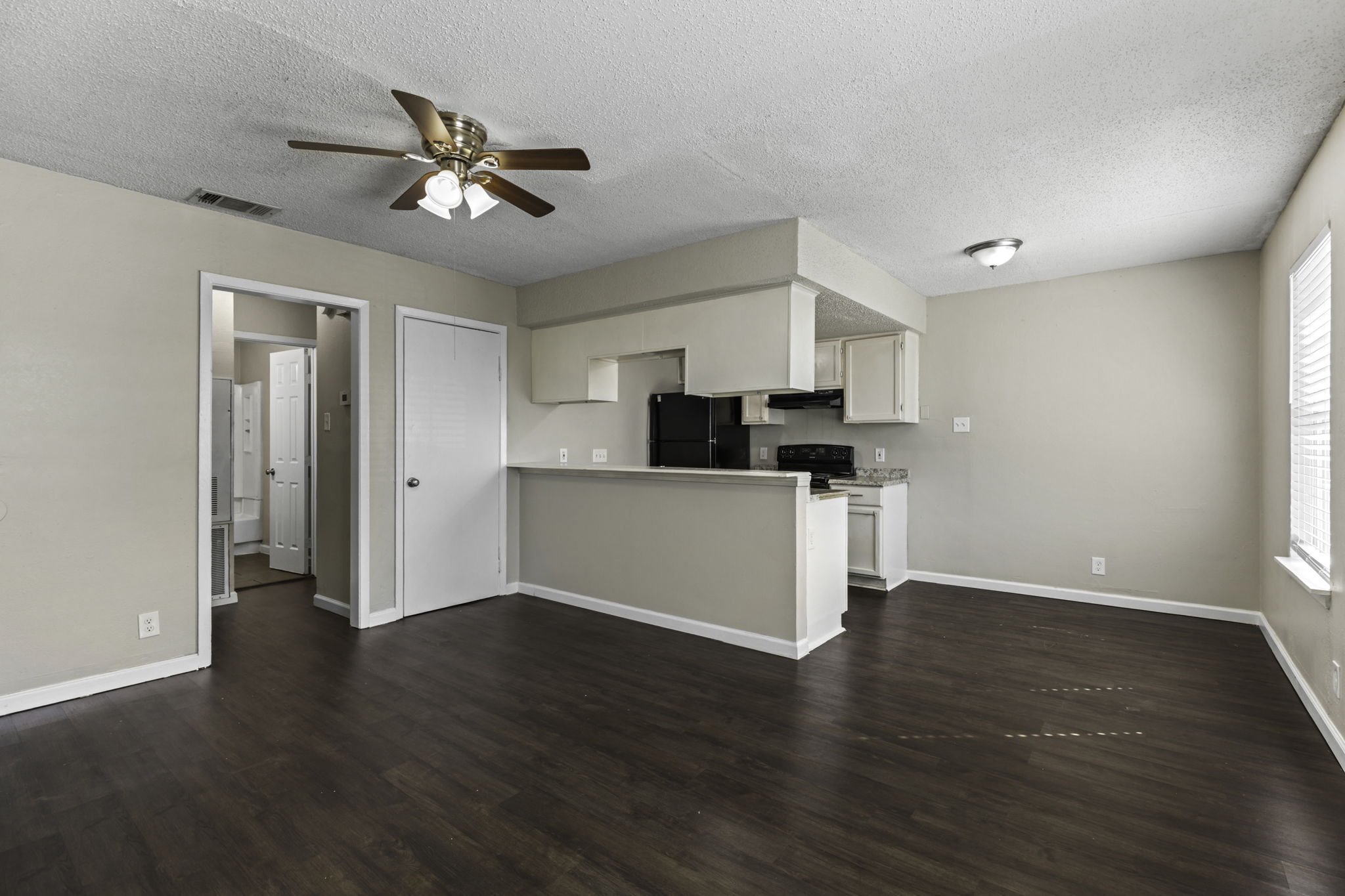6110 Wheless Cove, Unit F Austin, TX 78723 - Photo 11 of 12 Kitchen with a peninsula, light countertops, black appliances, dark wood-style flooring, and a ceiling fan