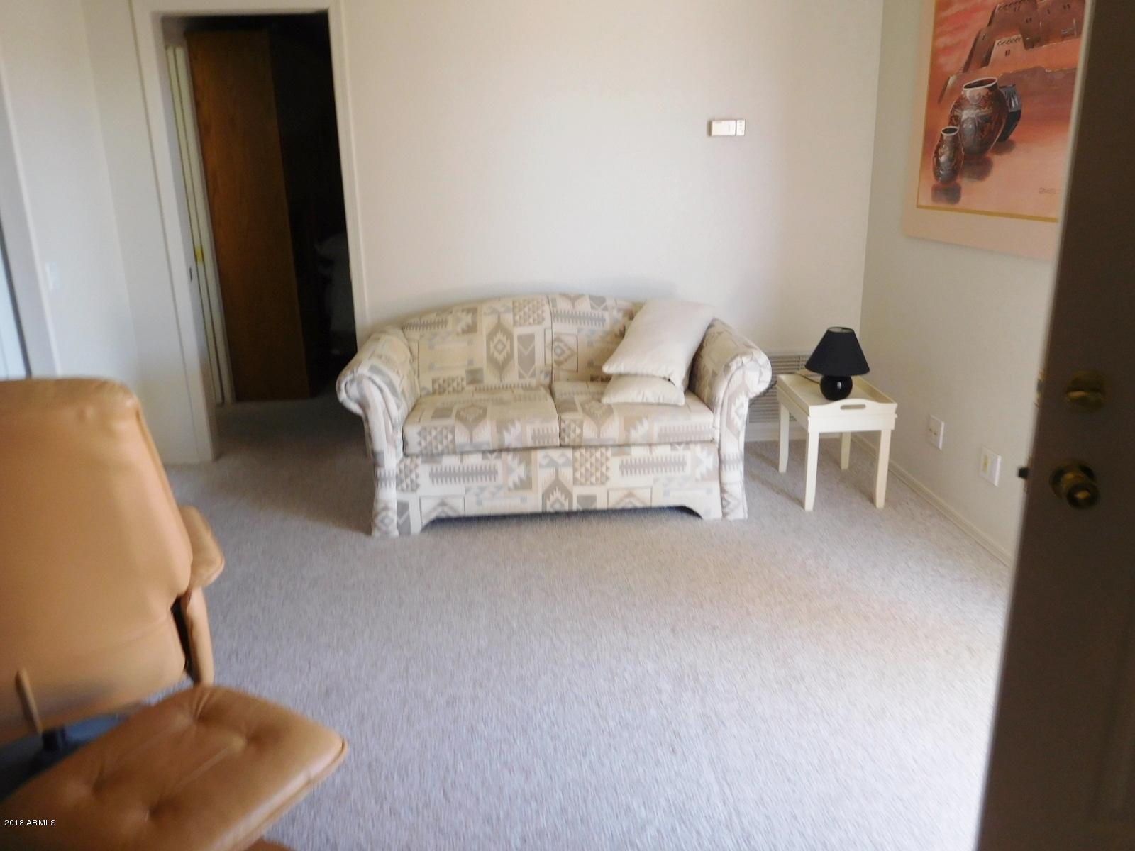 17200 West Bell Road, Unit 789 Surprise, AZ 85374 - Photo 4 of 9 a living room with furniture and a mirror