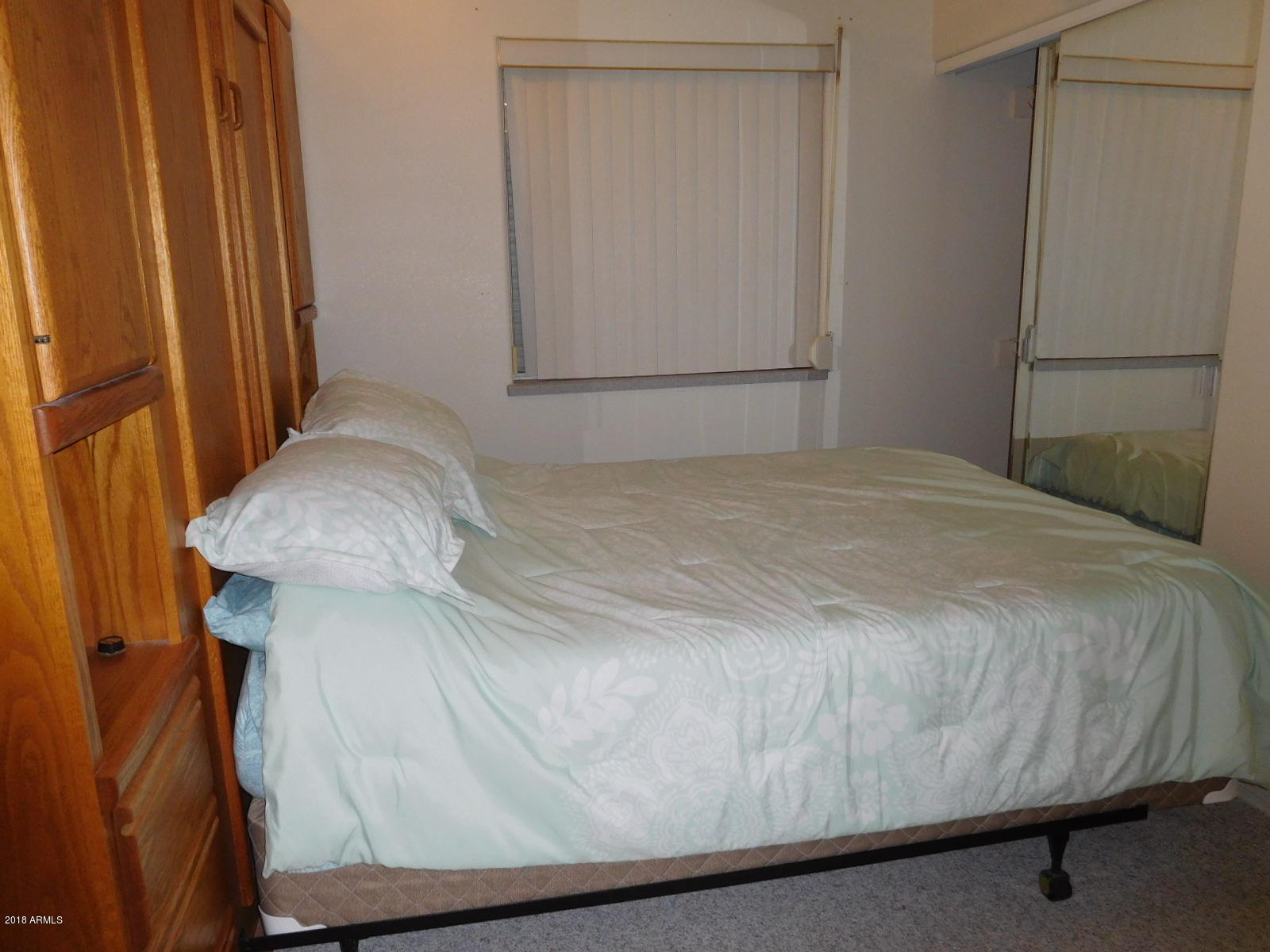 17200 West Bell Road, Unit 789 Surprise, AZ 85374 - Photo 6 of 9 a bedroom with a bed and a mirror