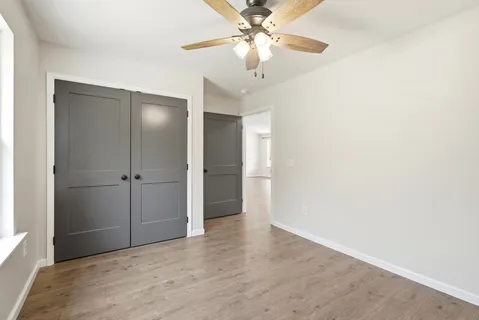 an empty room with fan and windows