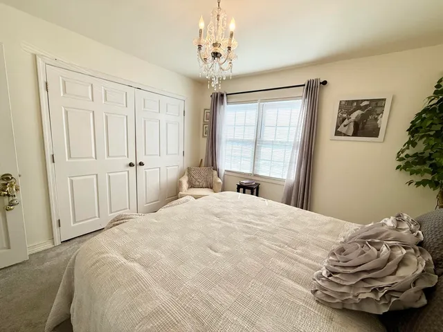 a bedroom with a bed and a chandelier
