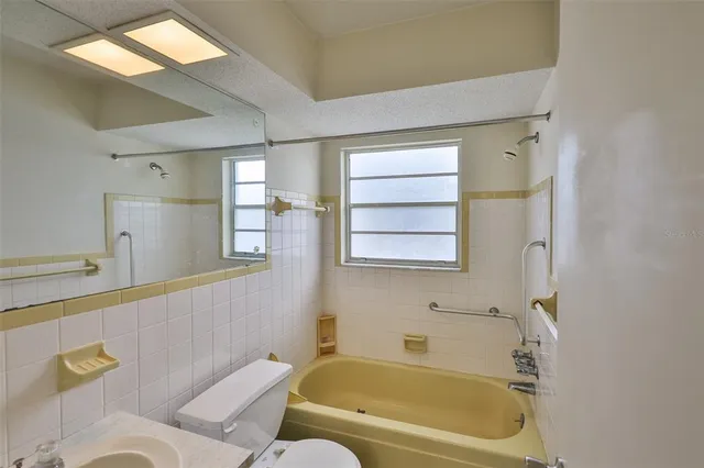 a bathroom with a bathtub shower and sink