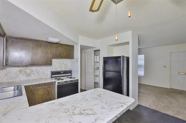 a kitchen with granite countertop a refrigerator and a sink