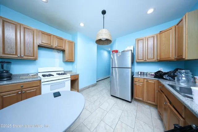 a kitchen with stainless steel appliances granite countertop a stove a refrigerator and a sink
